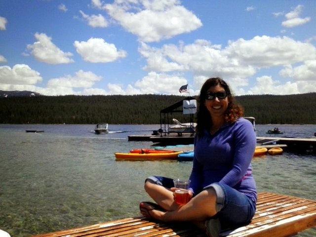 Susan enjoys the pure mountain sunshine while sitting on the dock after the race.